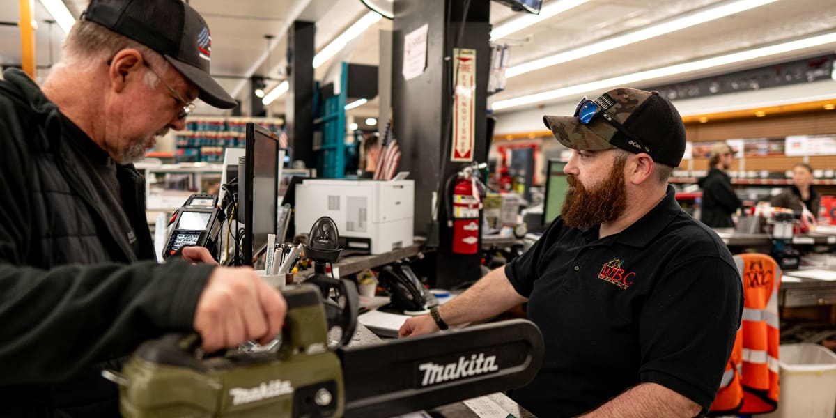 A customer and employee interact at the checkout counter inside Western Building Center