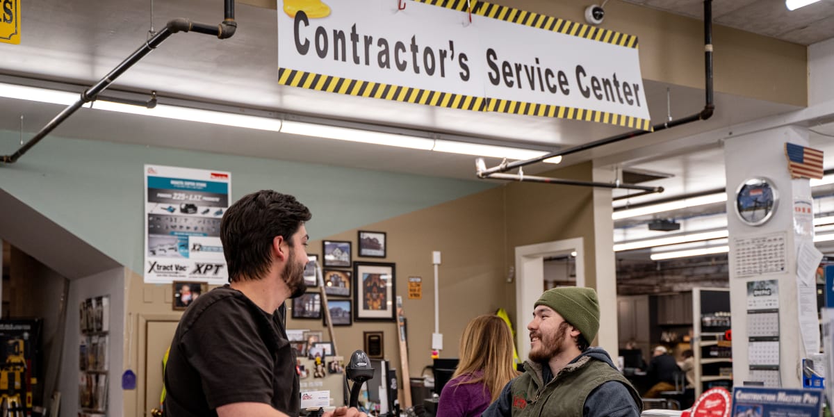 Interior shot of the Contractor's Service Center at Western Building Center showing two employees helping customers at the se