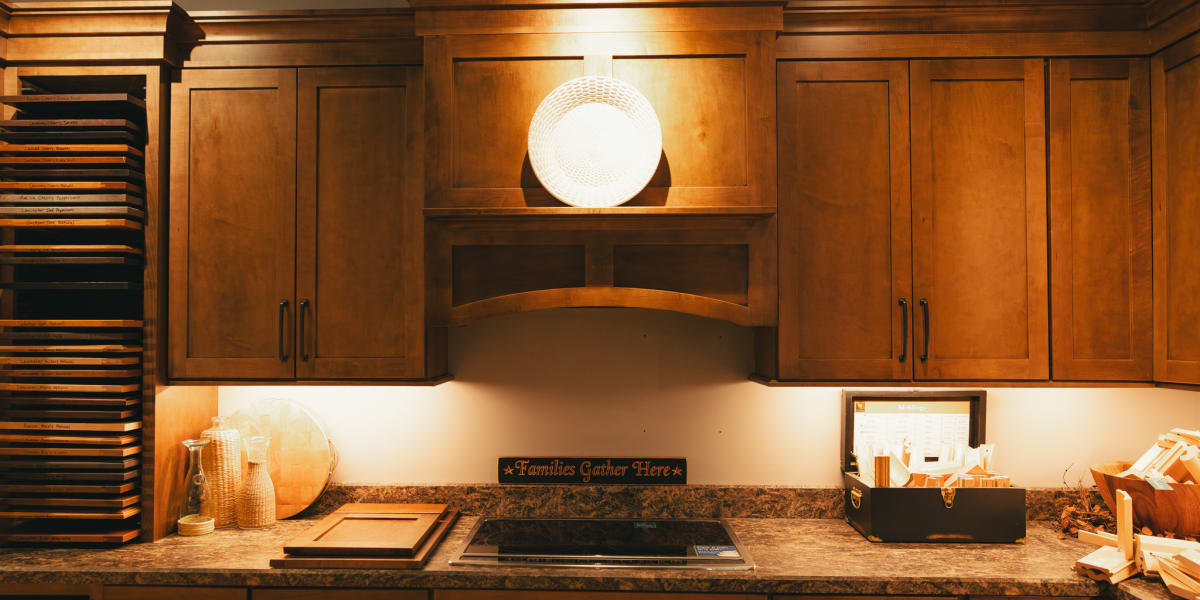 A beautifully designed kitchen showcasing warm wood cabinets with crown molding and traditional panel doors in a rich honey-o