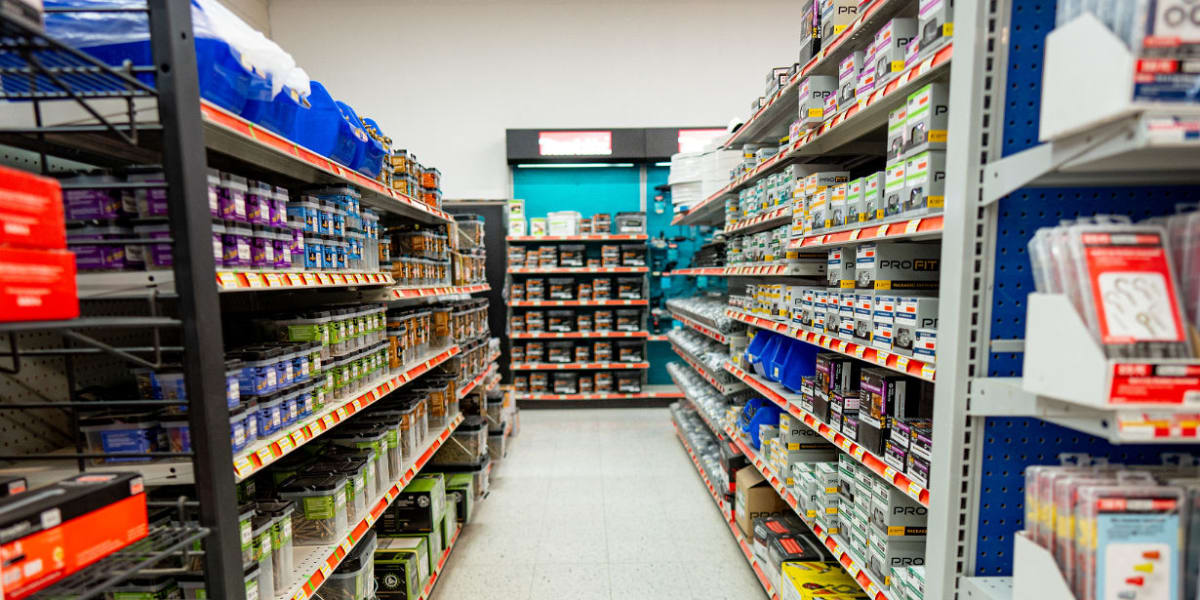 Interior view of a store aisle showing organized shelving with various products