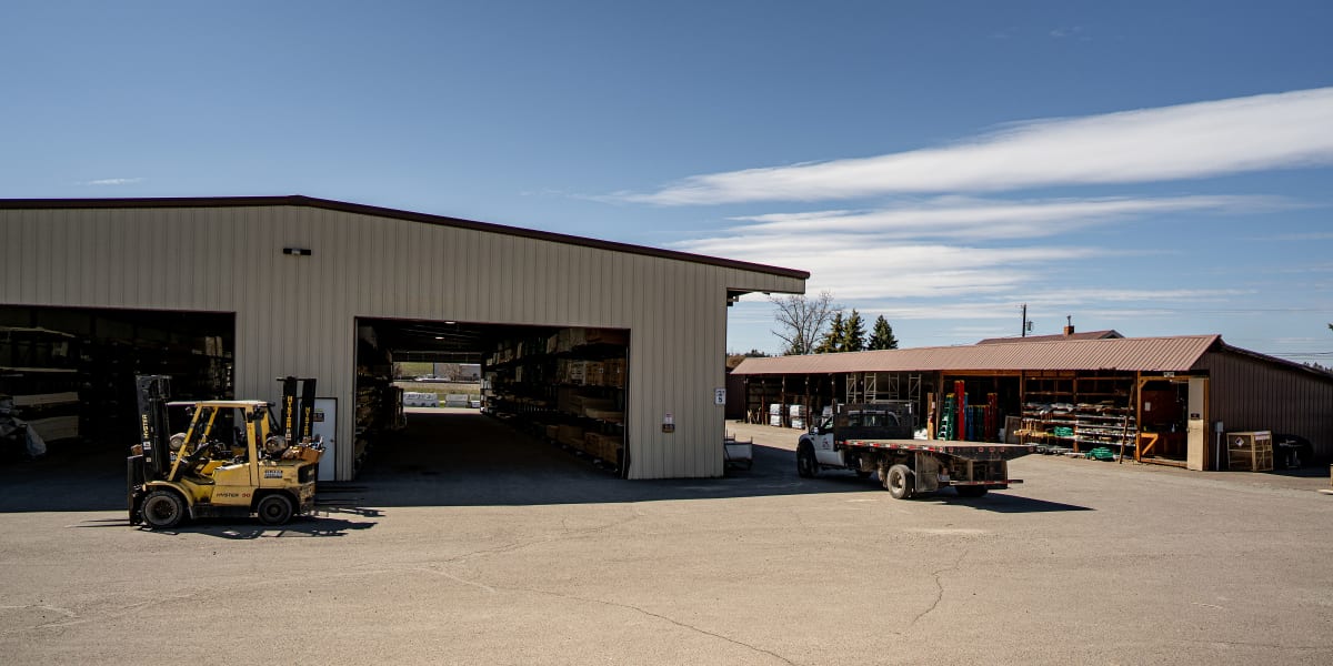Industrial warehouse and lumber yard facility with metal buildings featuring corrugated siding and roofing