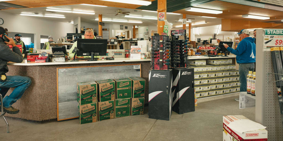 Interior view of a Western Building Center store showing the customer service counter area with an employee working at a comp