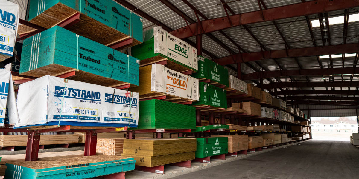 Interior warehouse view showing organized lumber storage with engineered lumber products stacked on red cantilever racking sy