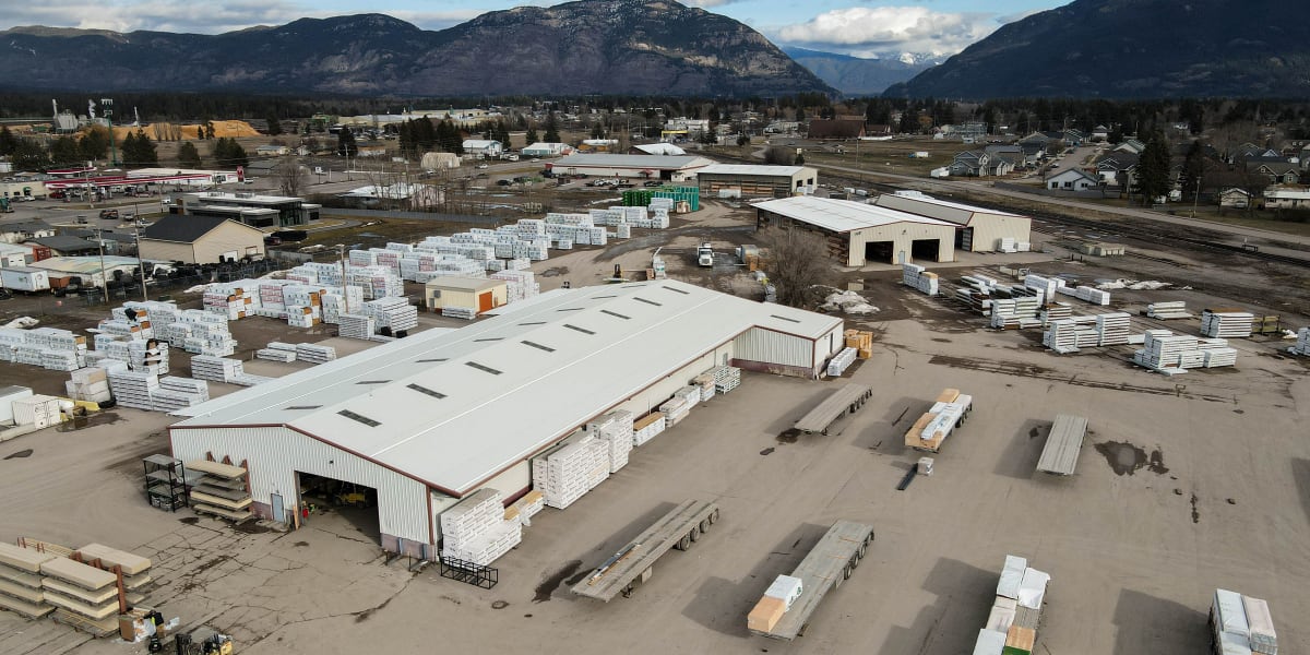 Aerial view of Western Building Center's Kalispell lumber yard and warehouse facility showing large industrial buildings with