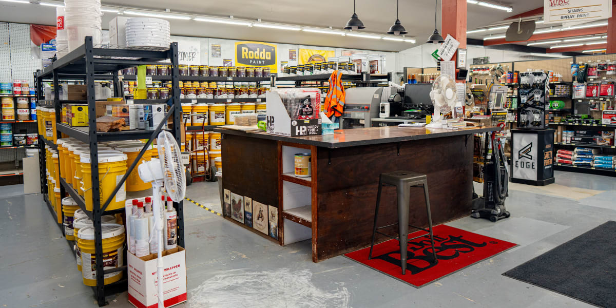 Interior view of the paint department showing a large paint mixing station with computer equipment and color matching tools