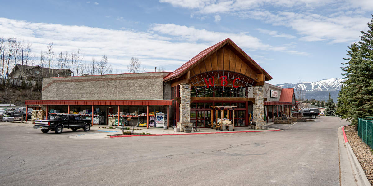 Exterior view of Western Building Center's Whitefish location showing the main store building with its distinctive stone and