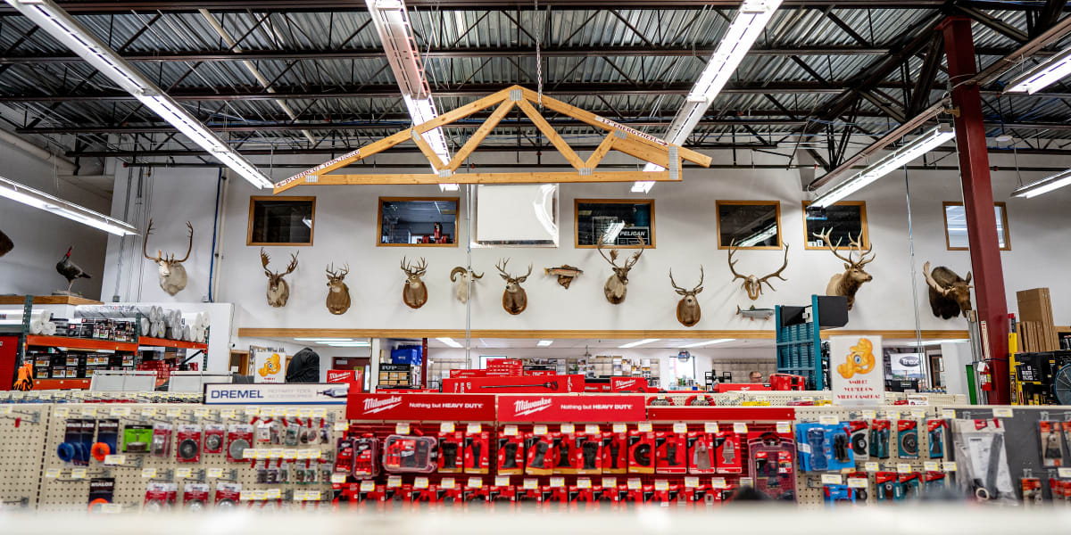 Interior view of a Western Building Center store showing the tools department with extensive Milwaukee tool displays on red p