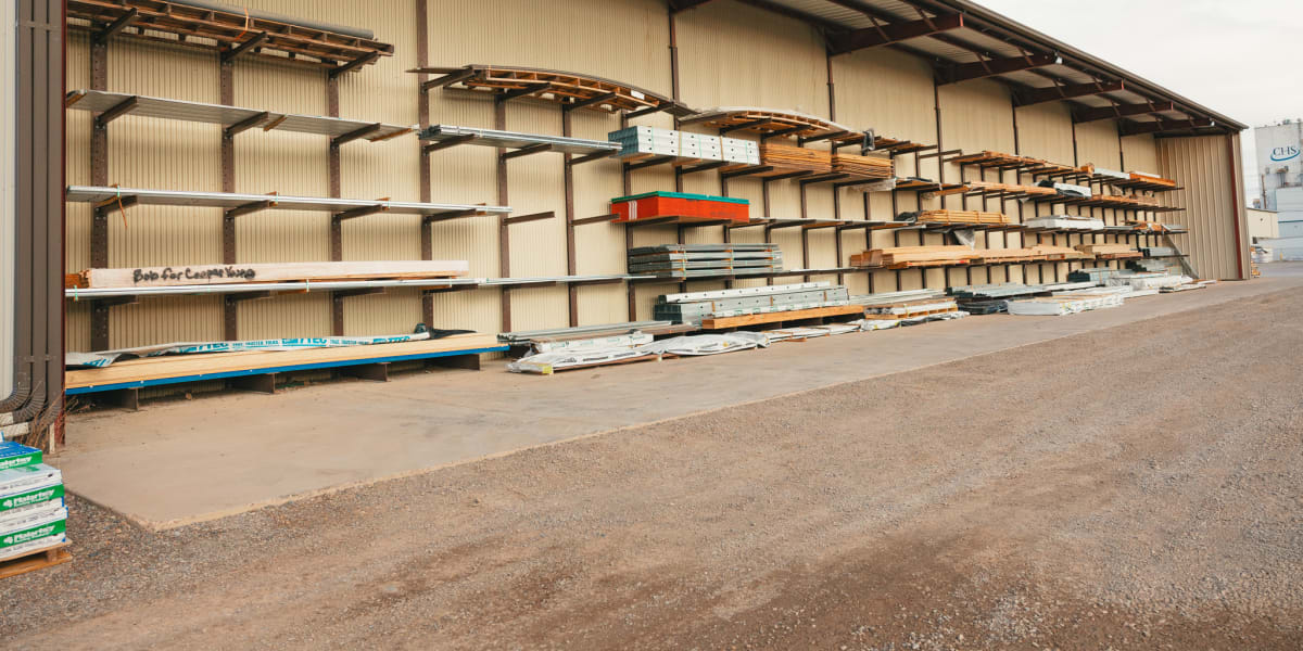An organized lumber yard storage facility showing extensive cantilever racking systems filled with various building materials