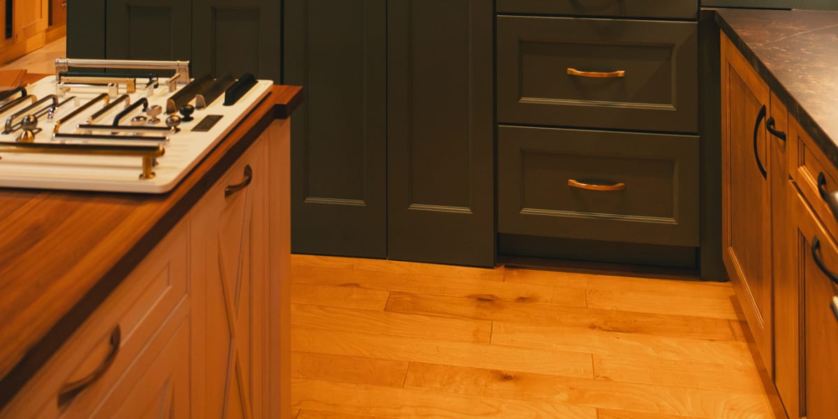 High-end kitchen featuring custom green painted cabinets with traditional raised panel doors and brass hardware