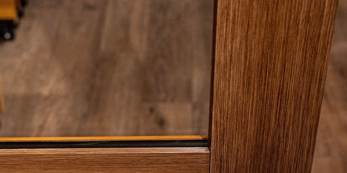 Close-up detail shot of a wooden door frame showing the corner joint construction and wood grain patterns