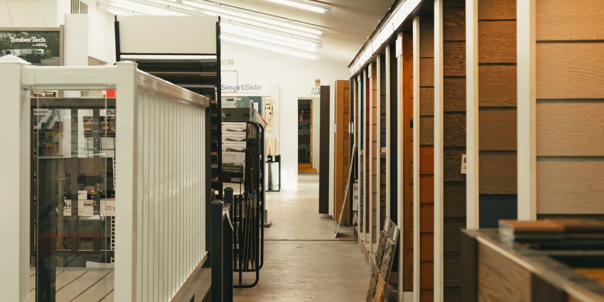 Interior view of a millwork showroom displaying various wood flooring samples and interior door options