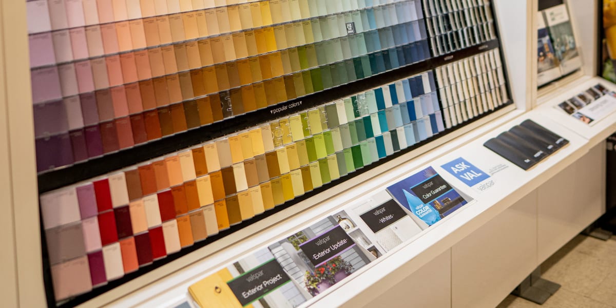 A comprehensive paint color gallery display in the paint department showing an extensive wall-mounted color selection system