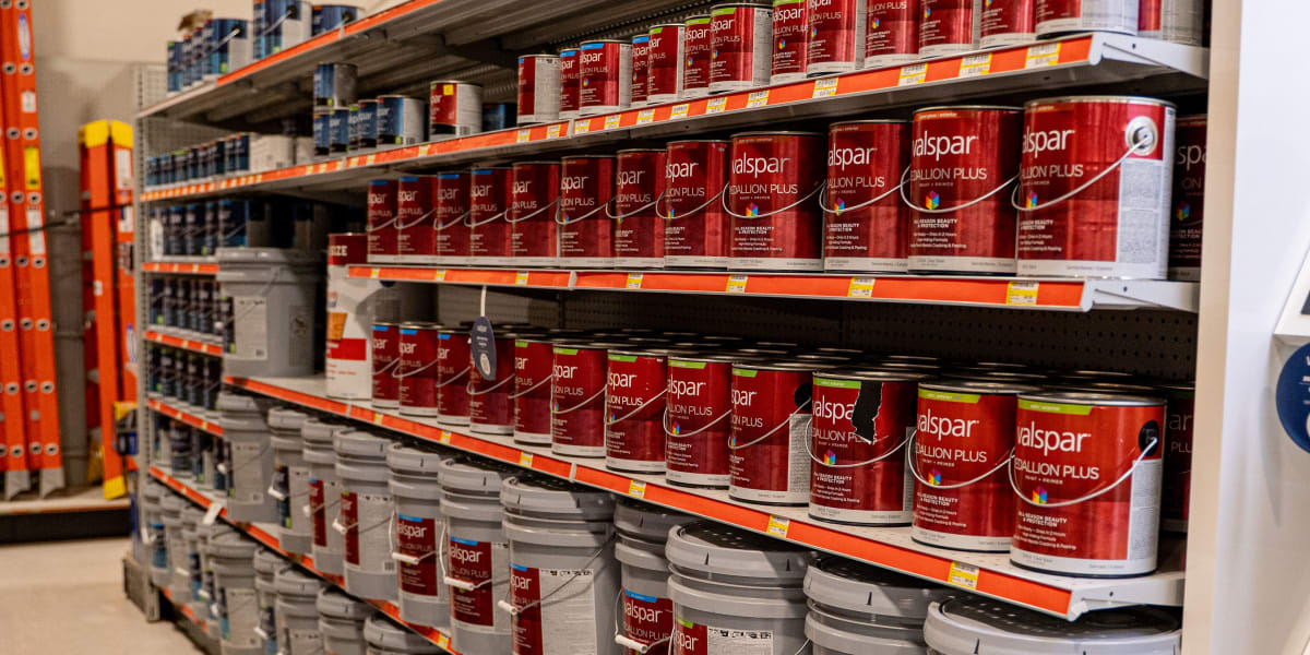 Interior paint aisle at Western Building Center showing multiple shelves stocked with Valspar paint products