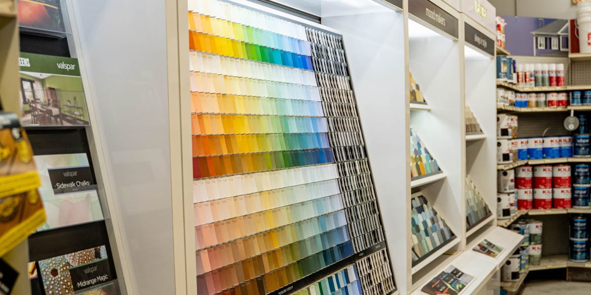 Interior view of the paint department showing a large Valspar color gallery display with hundreds of paint color samples arra