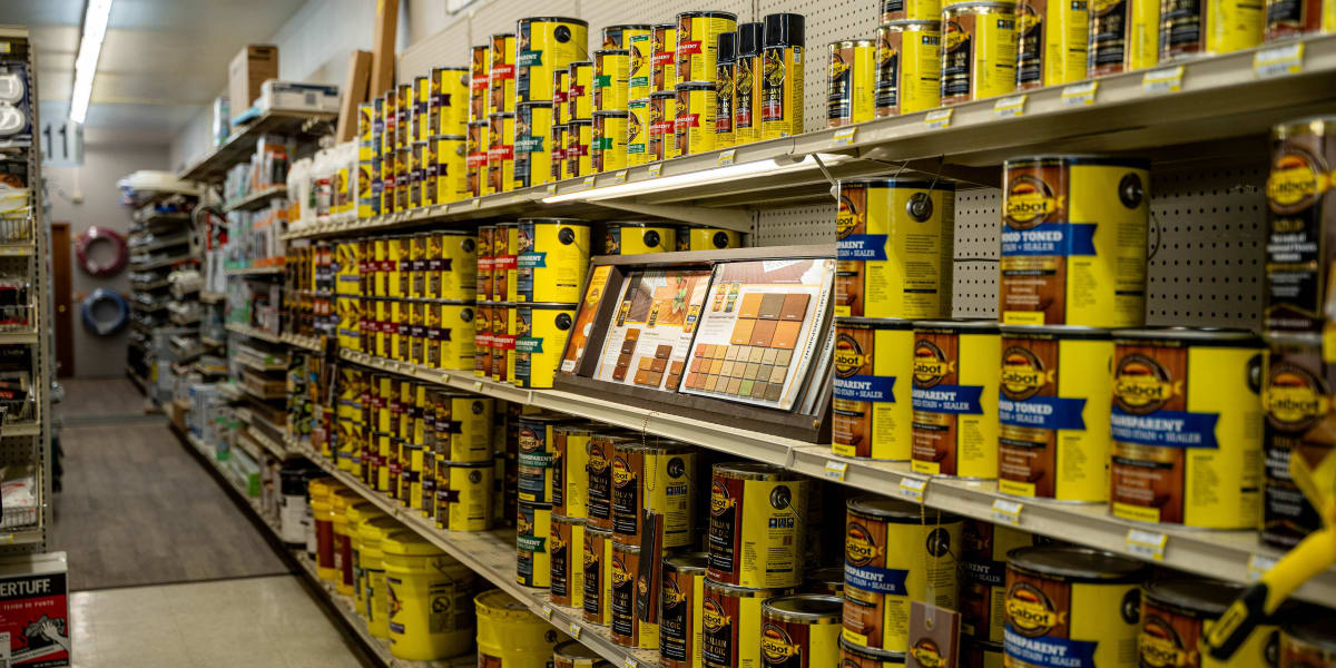 Interior view of the paint department showing extensive shelving displays filled with wood stain and finish products