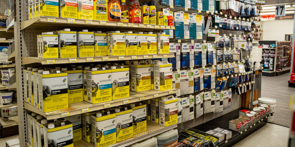 Interior view of the paint department showing extensive shelving stocked with paint products and supplies