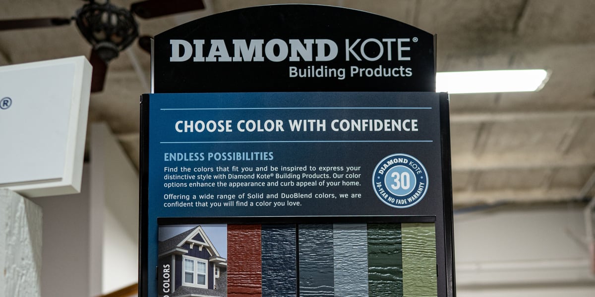 A Diamond Kote Building Products color selection display featuring multiple rows of siding material samples in various colors