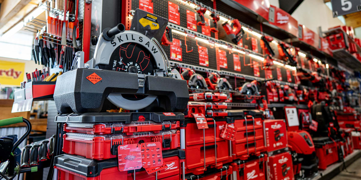 This image shows a well-organized tools section featuring a prominent SKILSAW circular saw display in the foreground with red