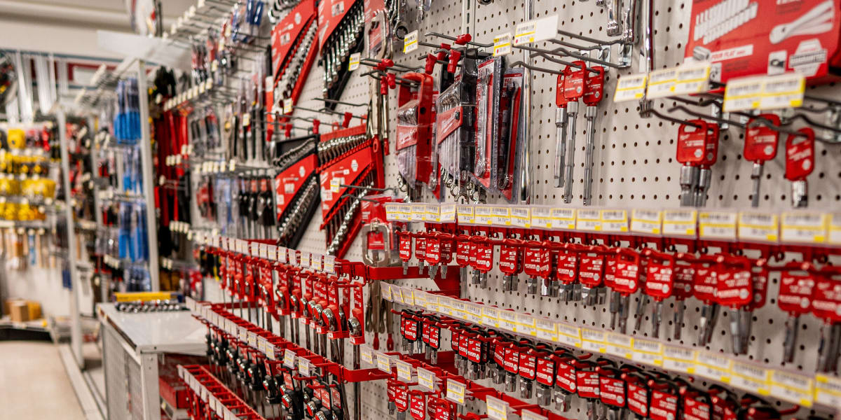 A well-organized hardware and tool aisle displaying an extensive selection of hand tools, wrenches, and hardware accessories