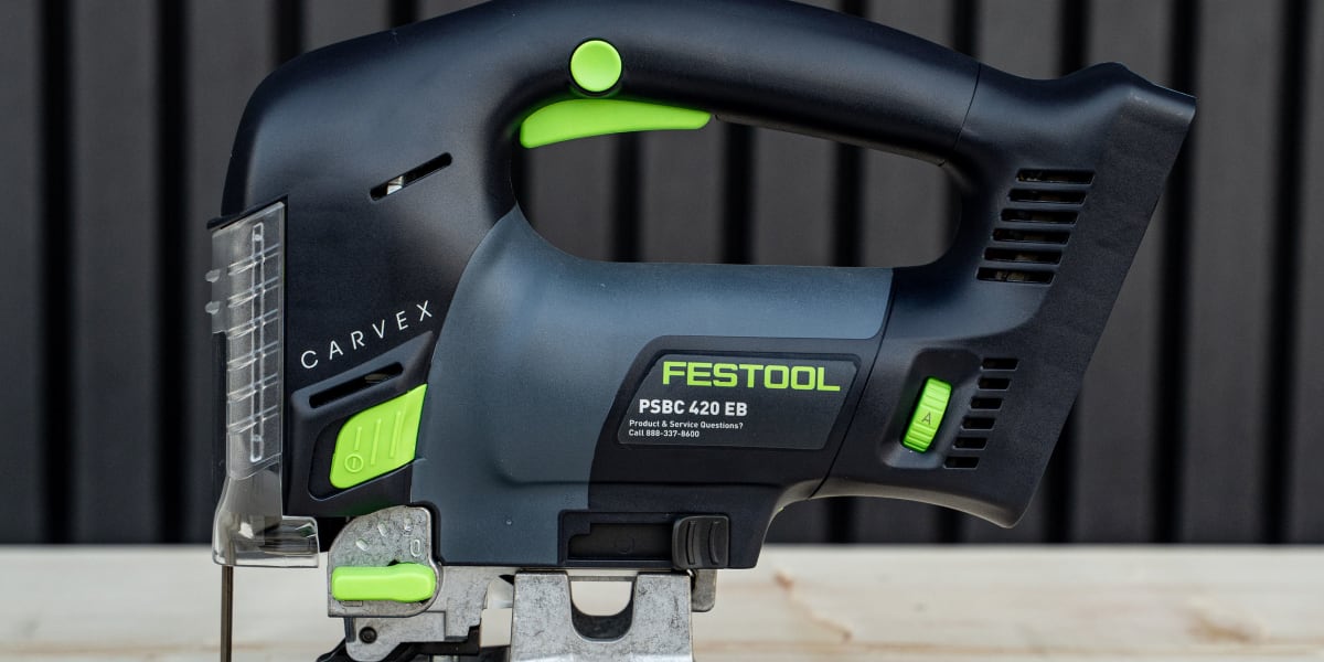 A Festool PSBC 420 EB cordless jigsaw with green and black color scheme positioned on a light wood surface