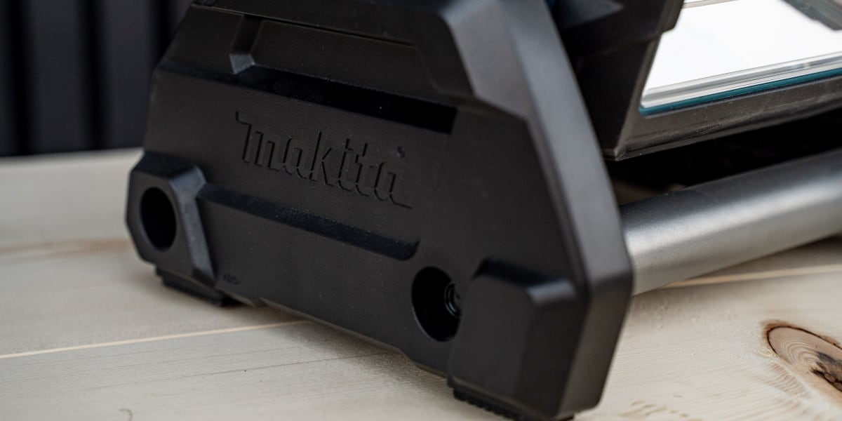 Close-up detail shot of a black Makita power tool, likely a circular saw or similar cutting tool, showing the brand name embo
