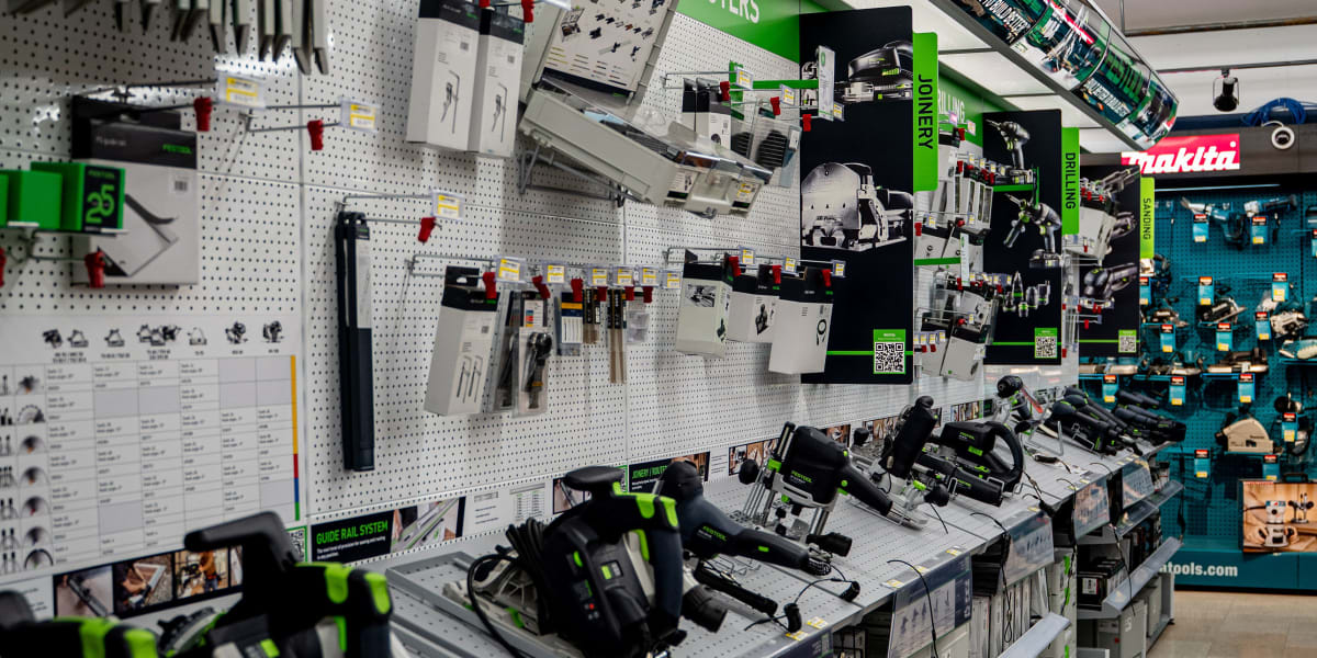 Interior view of a tools department showing a comprehensive display of power tools, primarily featuring Festool brand equipme