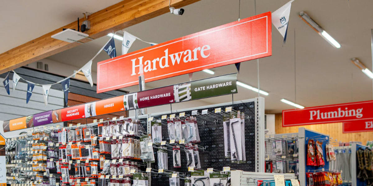 Interior view of the hardware department showing organized shelving units filled with various hardware items, tools, and home