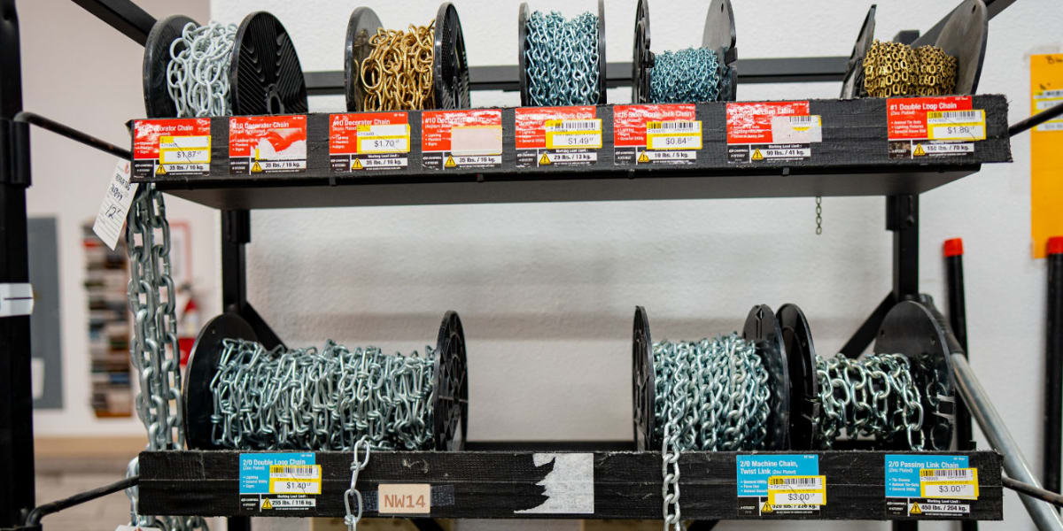 A retail display rack showing various chains and hardware organized on multiple shelves