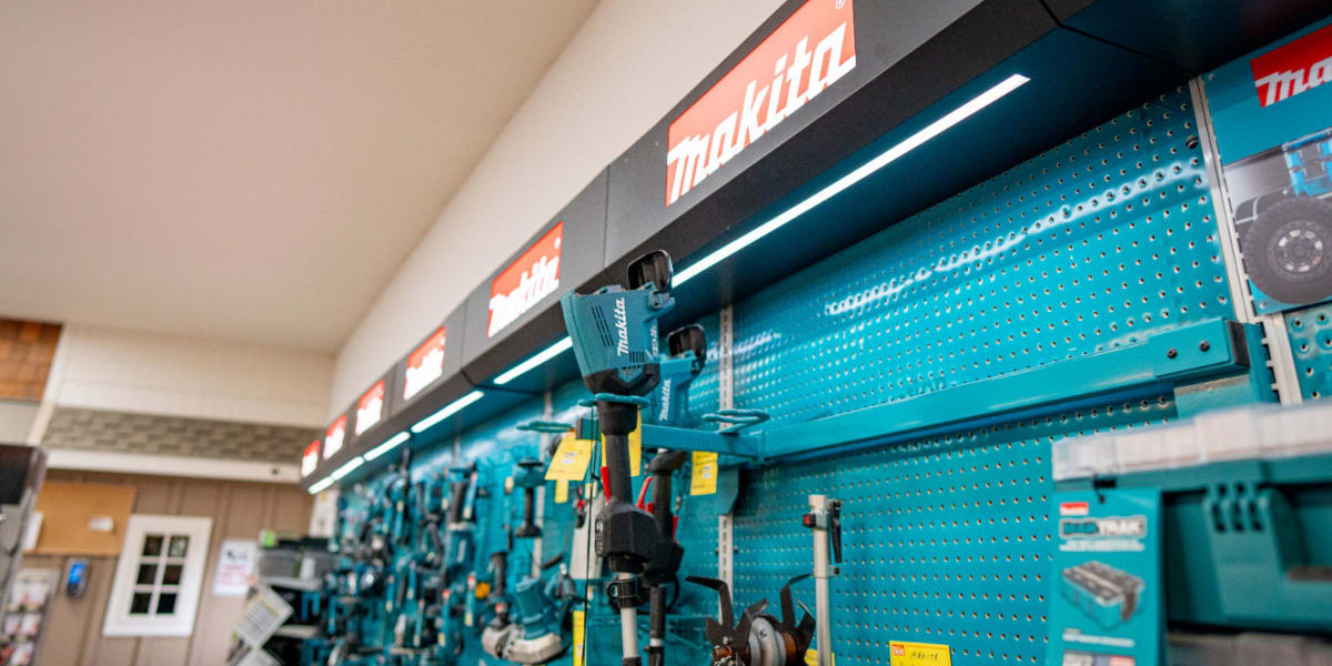 This image shows a well-organized tools department display with Makita power tools prominently featured on a turquoise pegboa
