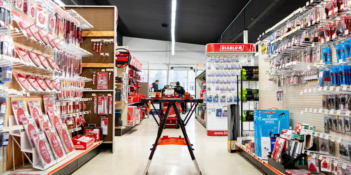 Interior view of the tools department showing two aisles lined with extensive hardware displays and tool accessories mounted