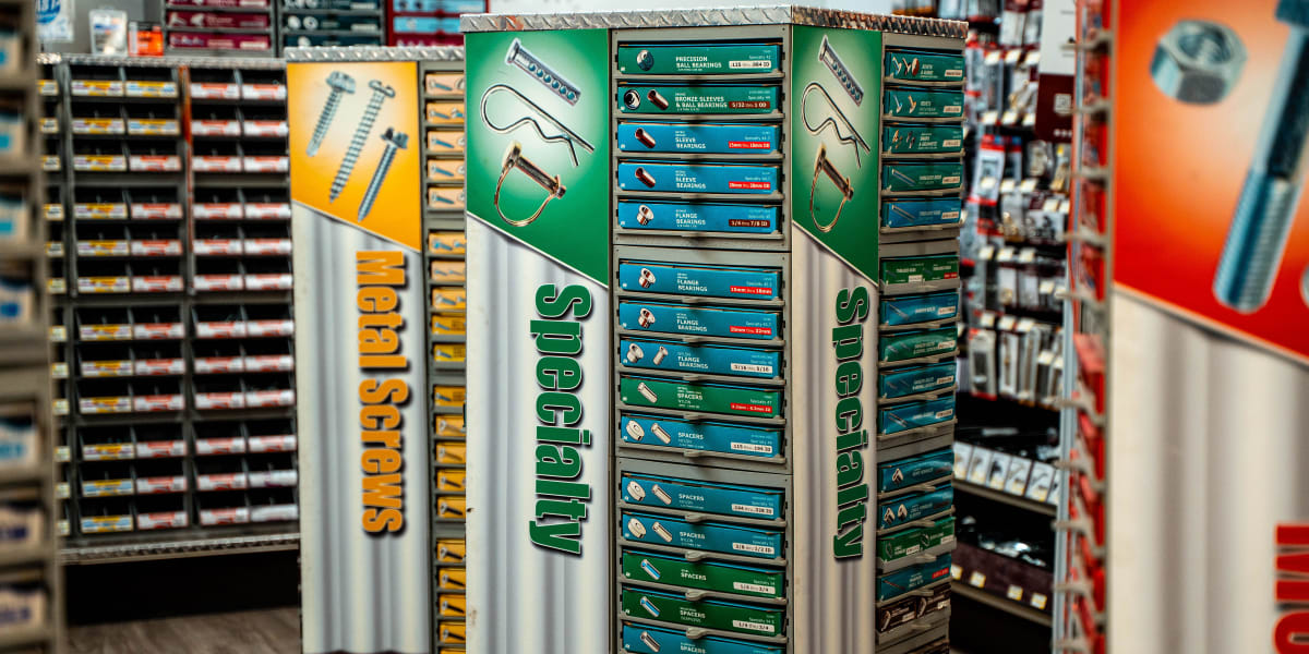 This image shows a rotating display rack of metal drill bits and specialty tools in the tools department of a hardware store