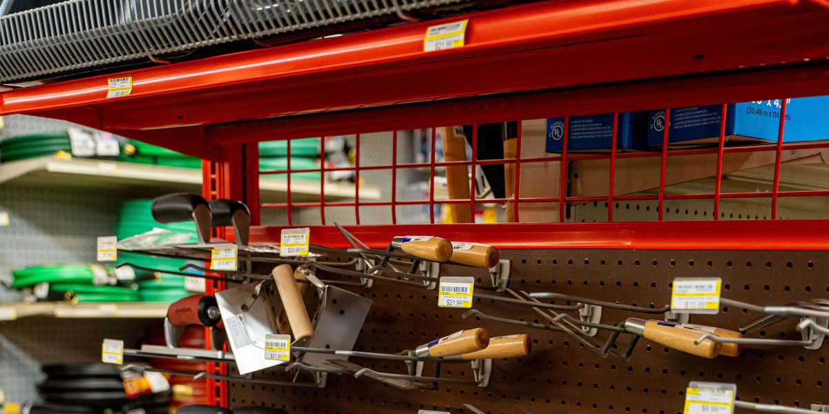 A well-organized tool display in a hardware store showing multiple rows of hand tools mounted on pegboard hooks