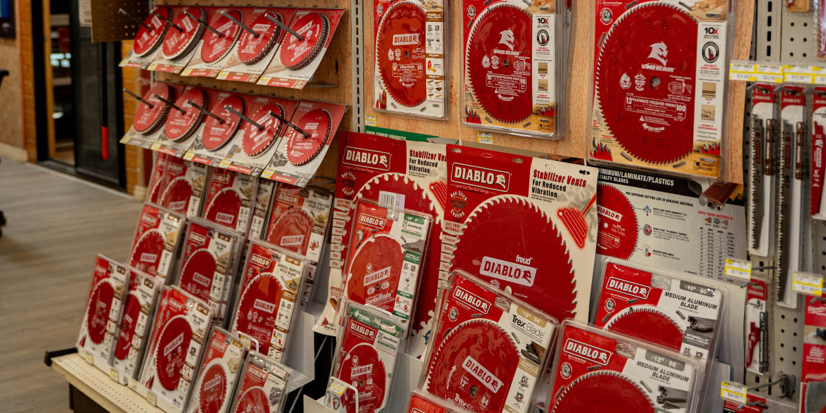A comprehensive display of Diablo circular saw blades in a hardware store aisle, featuring multiple shelving units with red-p