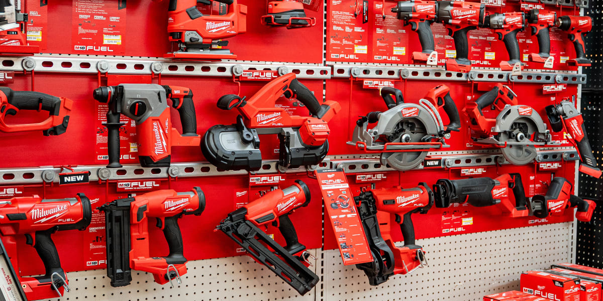 A comprehensive Milwaukee tool display in aisle 16 featuring multiple shelves of red Milwaukee M18 FUEL cordless power tools