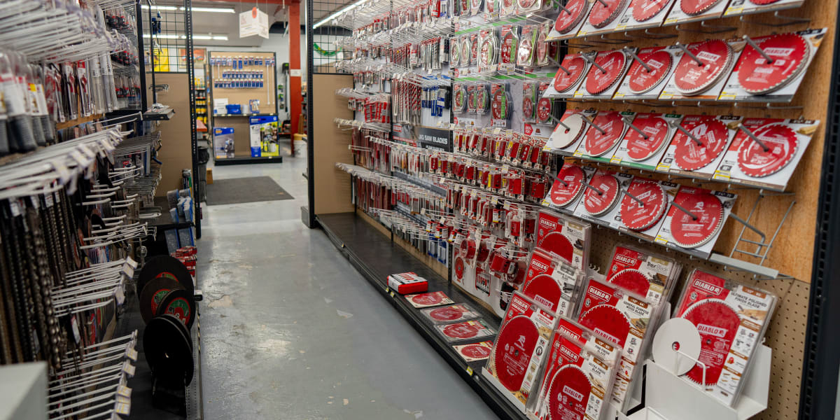 Interior view of a tools department aisle showing extensive displays of circular saw blades and cutting accessories
