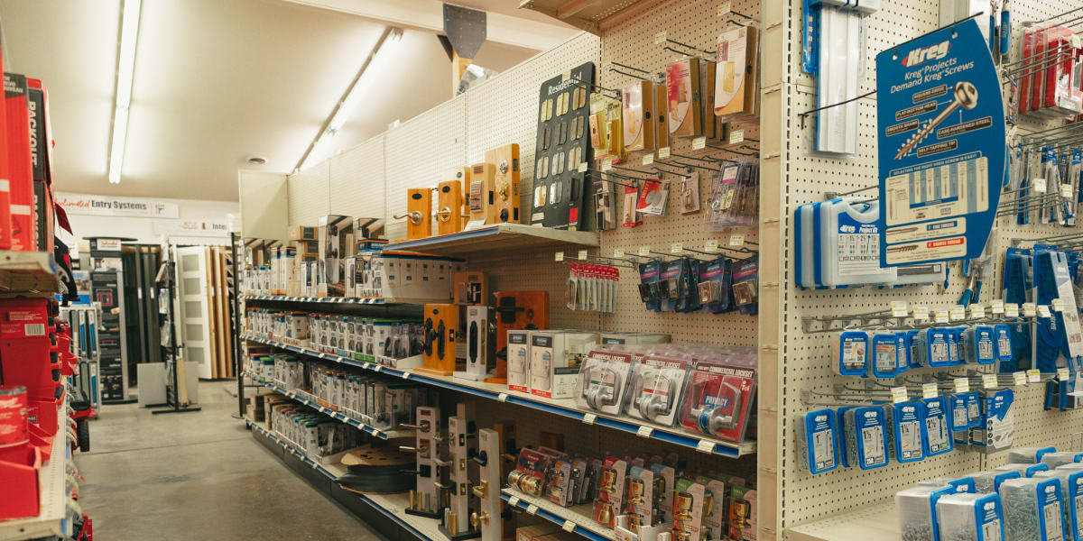 Interior view of a hardware and tools aisle showing extensive pegboard displays with various tools, hardware, and accessories