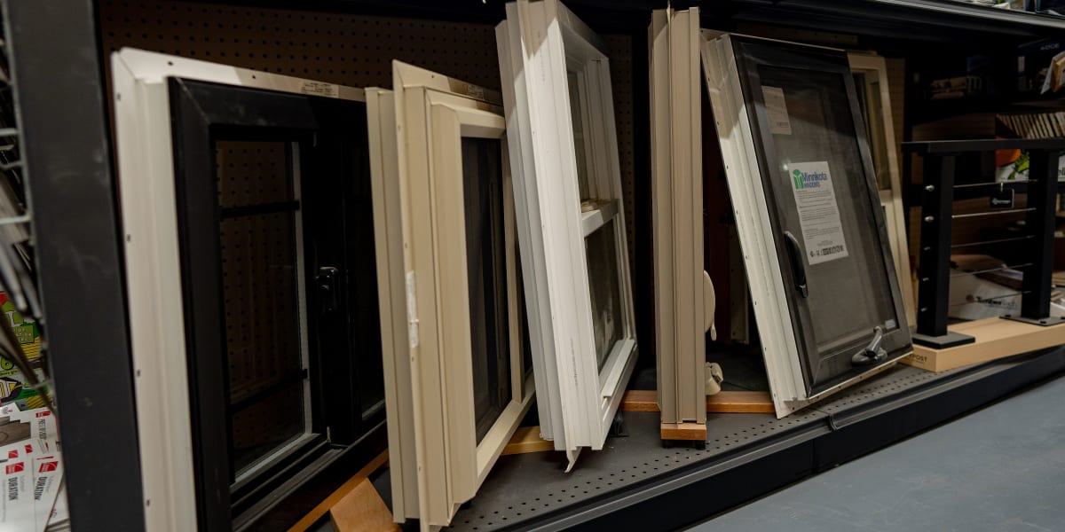 A store display showing multiple window samples and frames arranged on shelving units