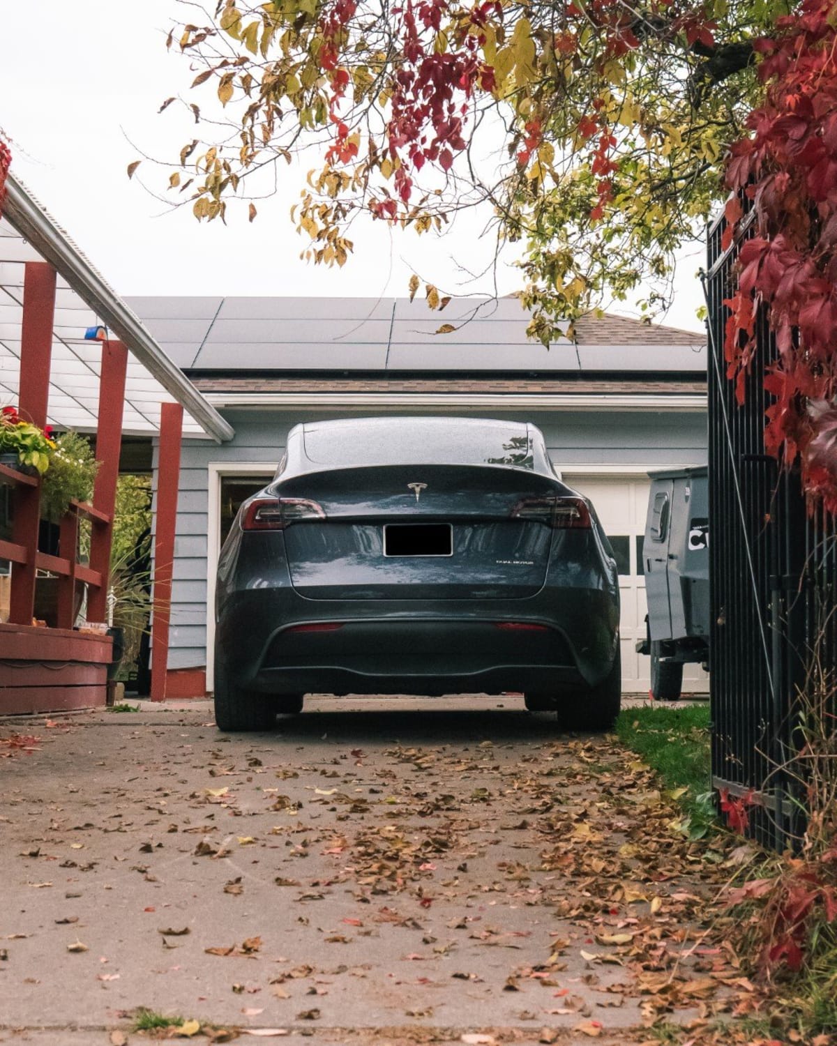 An electric car parked at a Montana home with a rooftop solar array behind it