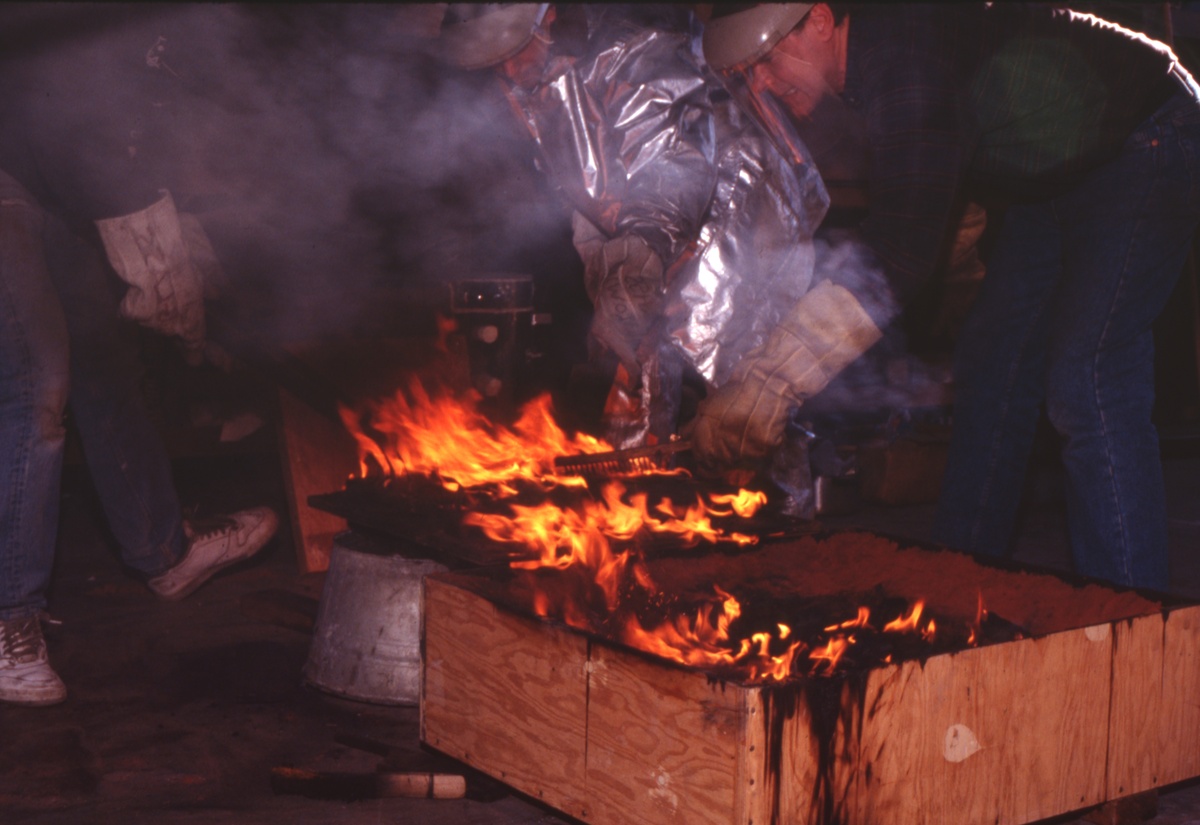 Lifting the hot glass sculpture from the flaming sand mold