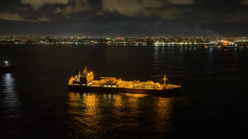 Illuminated tanker vessel at night in Santo Domingo port, reflecting golden light across dark Caribbean waters in commercial vessel photography