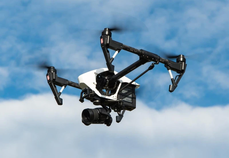 Professional white and black drone capturing aerial view against blue sky with clouds, aerial photography Santo Domingo