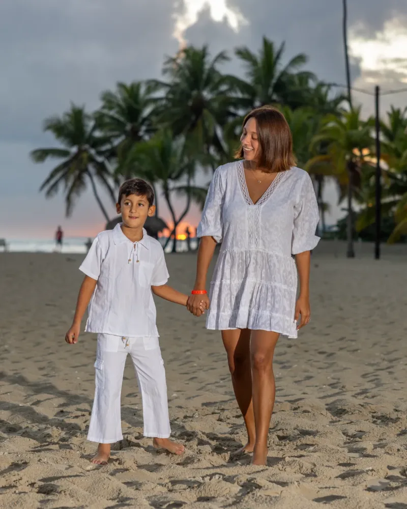Mother and son walk hand in hand on the beach at sunset in Santo Domingo, family beach photography with golden light