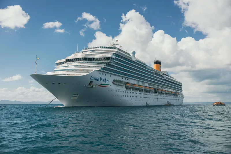 Costa Pacifica cruise ship anchored in turquoise waters of Punta Cana, Dominican Republic, with blue sky and white clouds