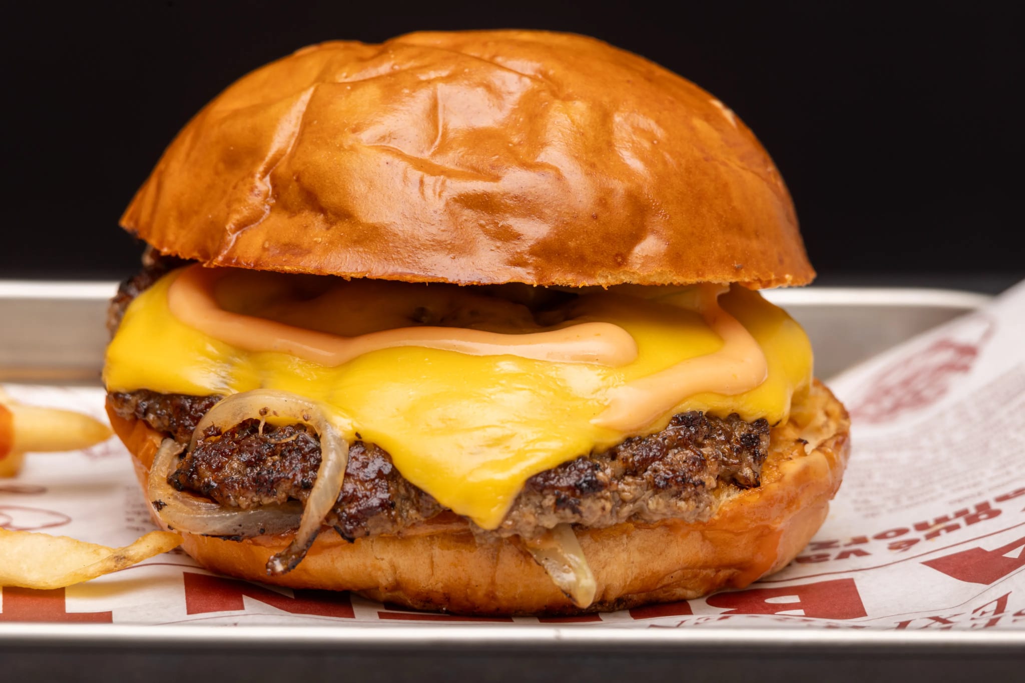 Classic cheeseburger on a branded metal tray