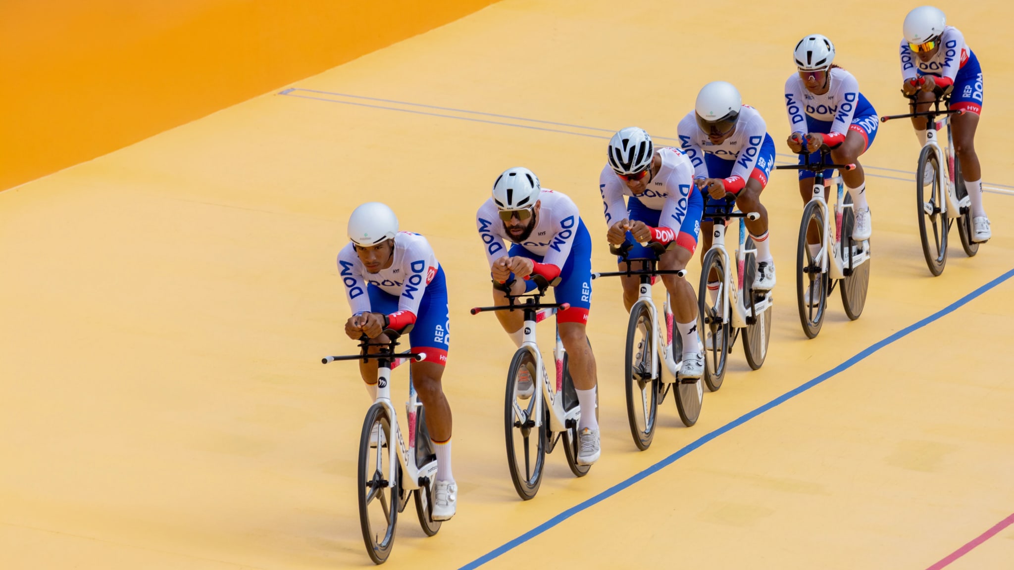 Dominican Republic team pursuit cyclists in a line on the velodrome