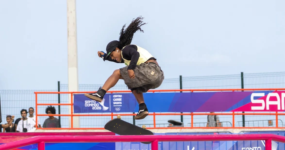 Skateboarder airborne performing a trick on a skate park ramp during a competition
