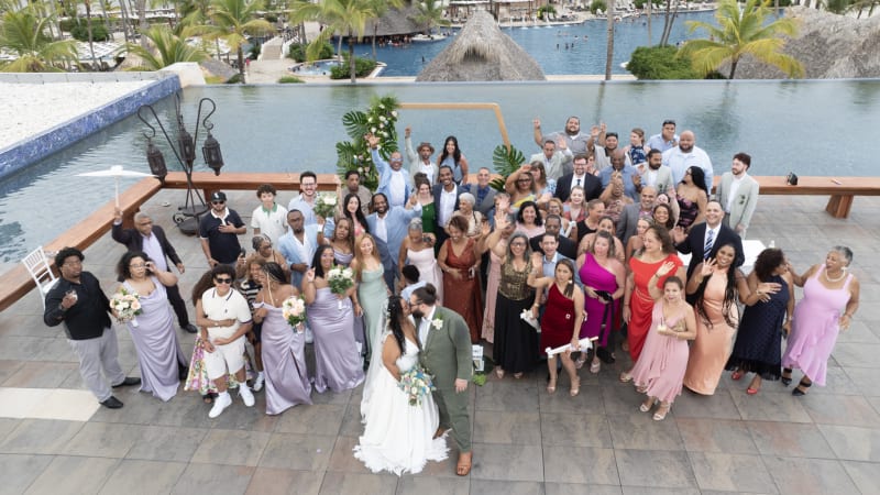 Sesión de boda con setenta invitados en Punta Cana junto a laguna, novia en blanco y novio en verde, fotógrafo de bodas profesional