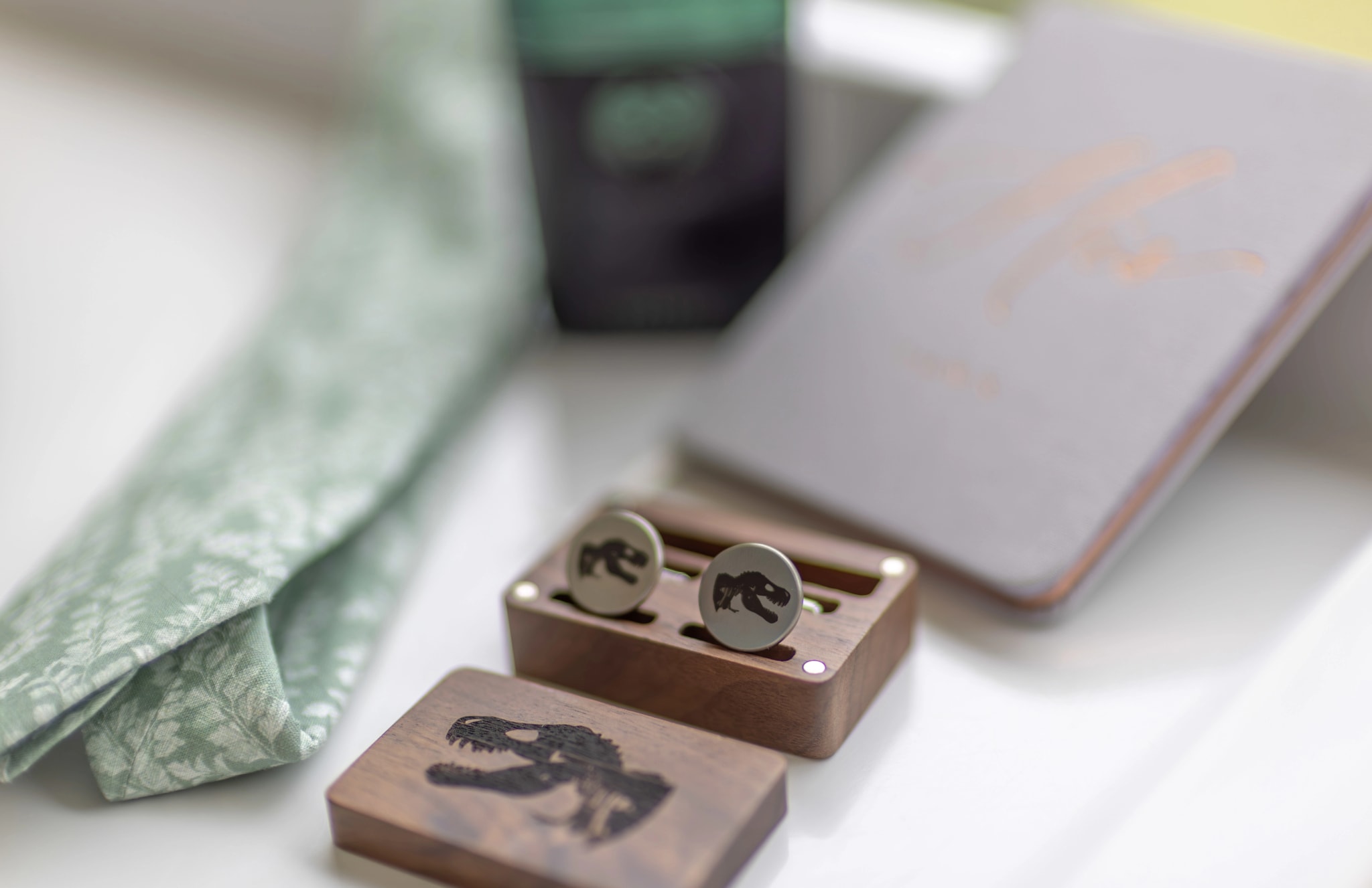 Gemelos y accesorios del novio en una caja de madera con grabado de dinosaurio
