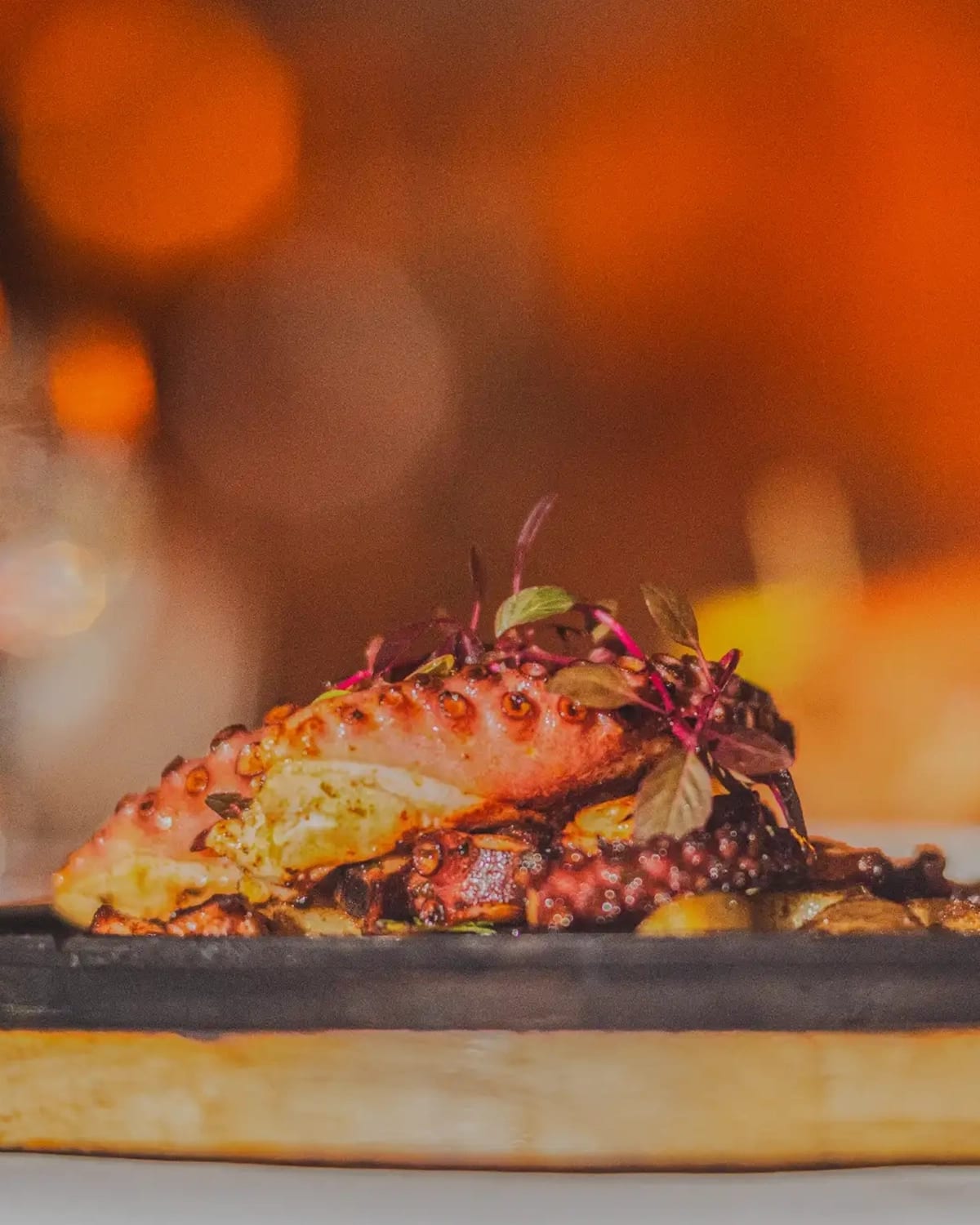 Primer plano de pulpo a la parrilla con bordes caramelizados en sartén caliente