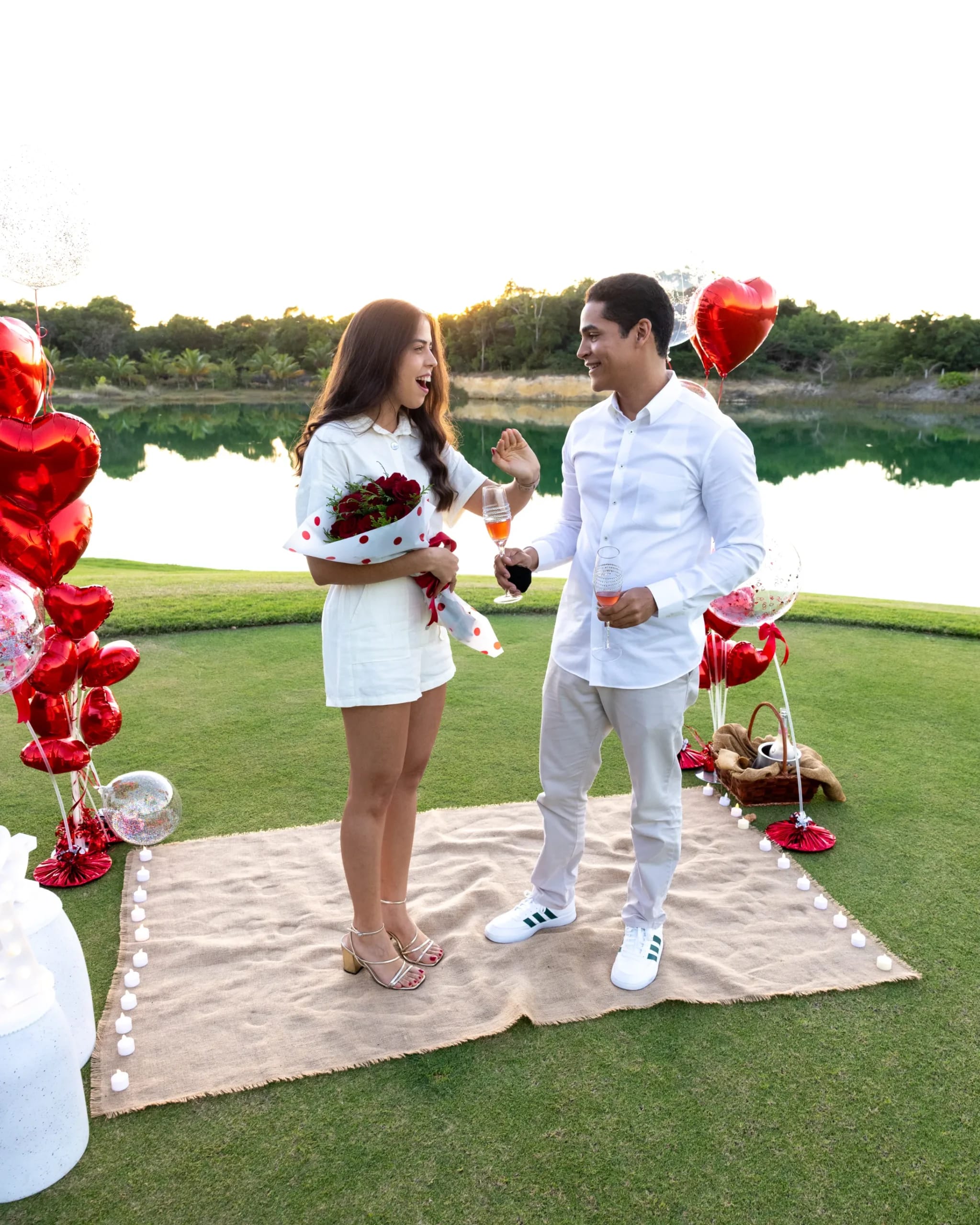 Pareja recién comprometida riendo y brindando durante su sesión de propuesta en Punta Cana